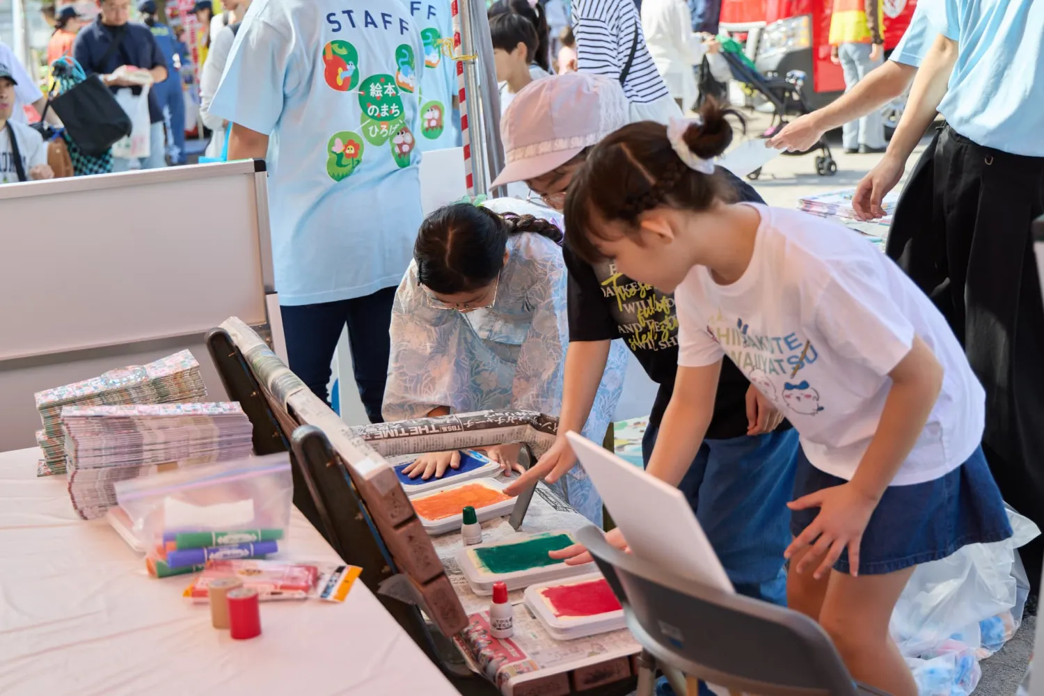 手形アートのためにインクを手につける子どもたち