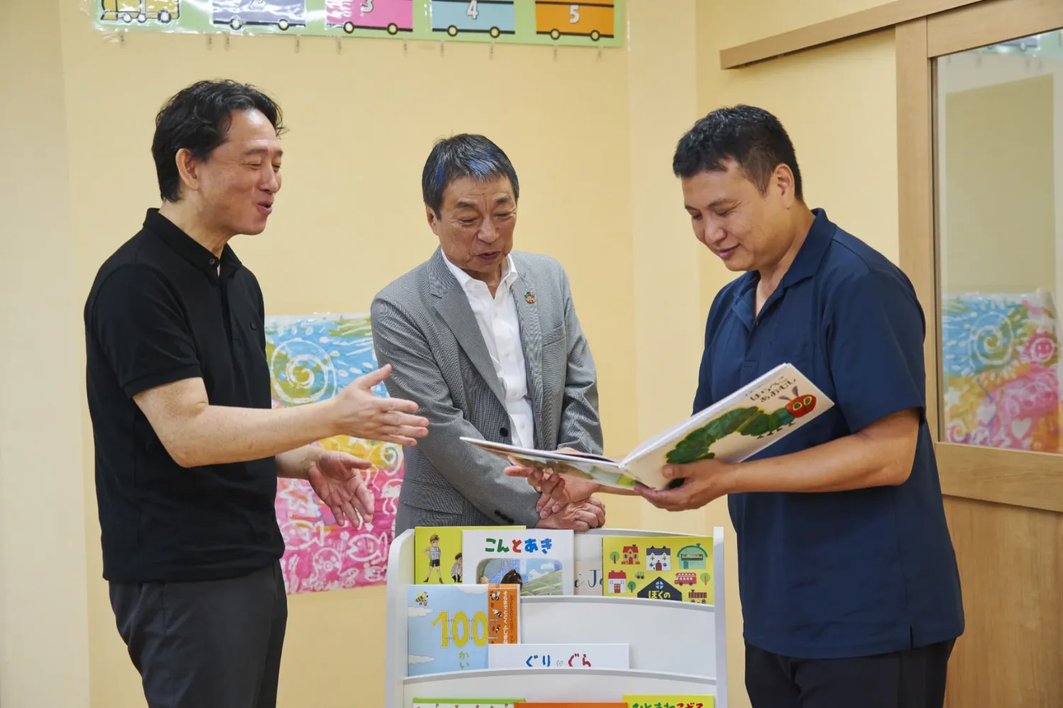 絵本を眺める金柿さん（左）、永塚さん（中央）、神立さん（右）